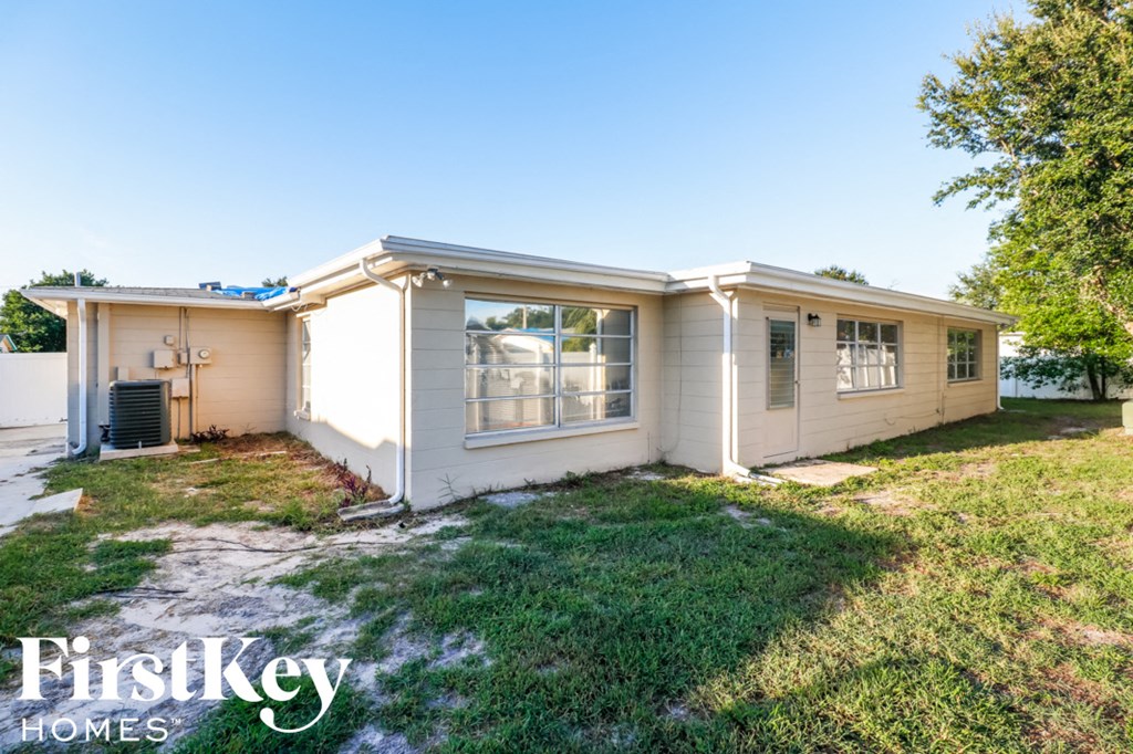 a small white house with a yard and grass