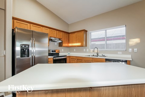 A kitchen with wooden cabinets and a stainless steel refrigerator.