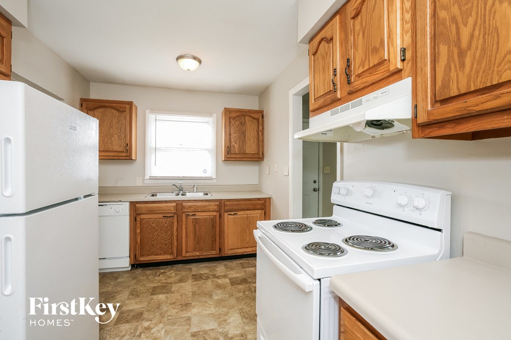 a kitchen with white appliances and wooden cabinets and a white stove