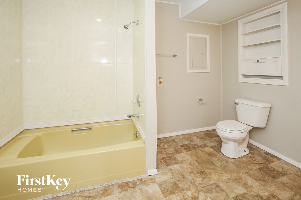 a bathroom with a toilet and a tub and a shower