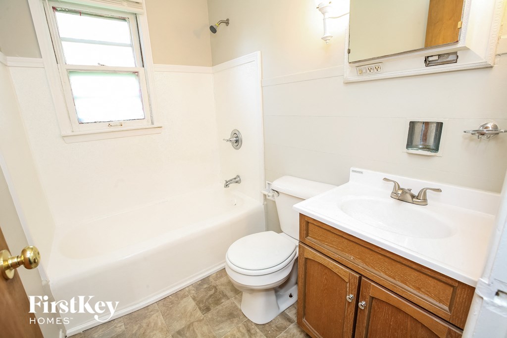a bathroom with a toilet and a sink and a tub