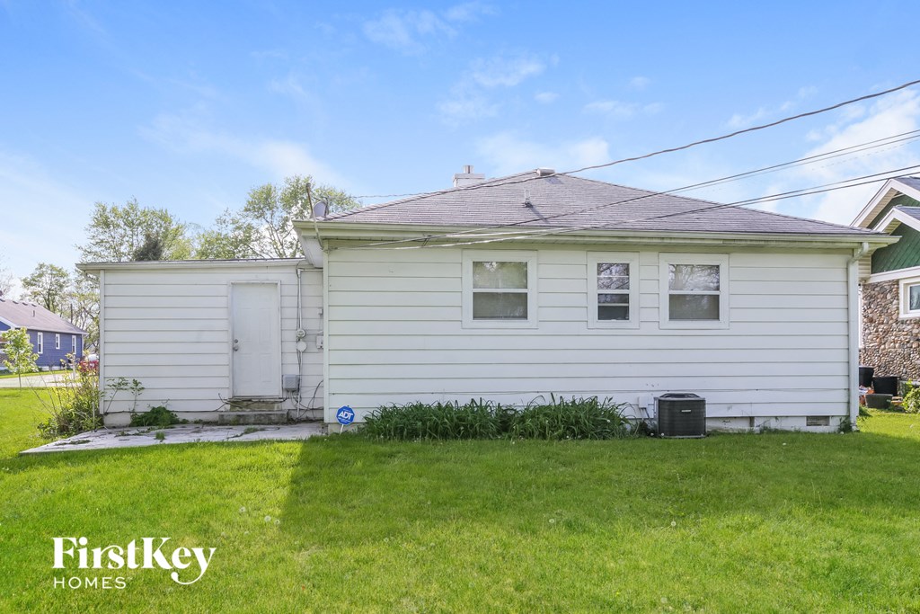 a small white house with a yard and grass