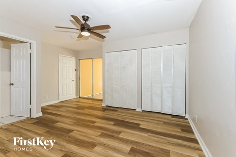 a living room with wood flooring and a ceiling fan