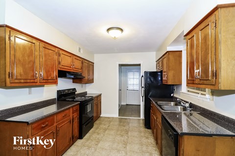 A kitchen with wooden cabinets and black appliances.