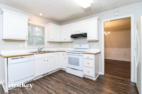A kitchen with white cabinets and appliances.