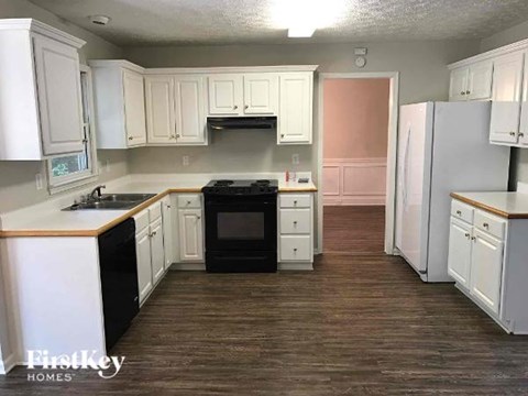 A kitchen with white cabinets and a black stove top oven.