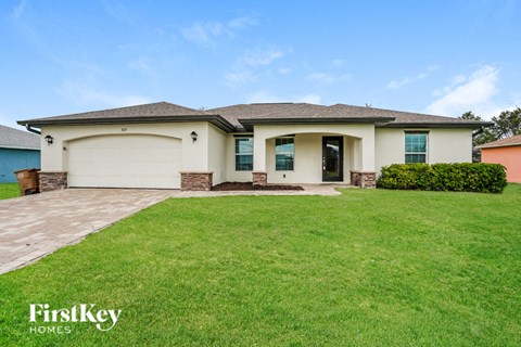 A house with a garage and a lawn in front.