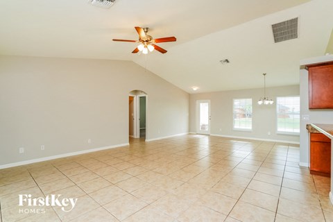 A spacious room with a ceiling fan and tiled floor.