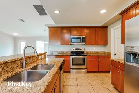 A kitchen with wooden cabinets and a granite countertop.