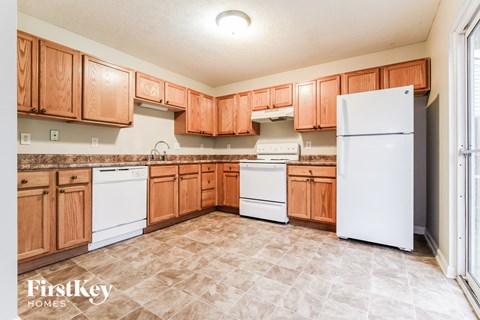 A kitchen with wooden cabinets and a white refrigerator.