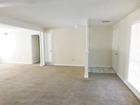 an empty living room with white walls and carpet