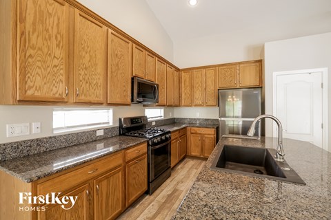 a kitchen with wooden cabinets and granite counter tops and a sink
