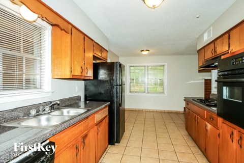 A kitchen with wooden cabinets and black appliances.