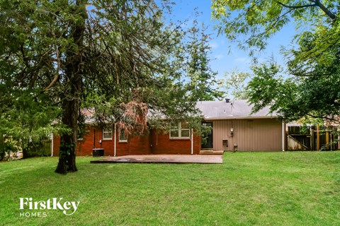 A house with a lawn and trees in front of it.