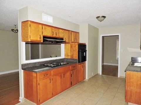 A kitchen with wooden cabinets and black appliances.