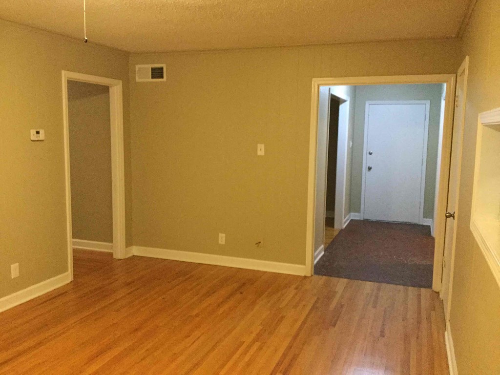 A room with wood floors and two doors.