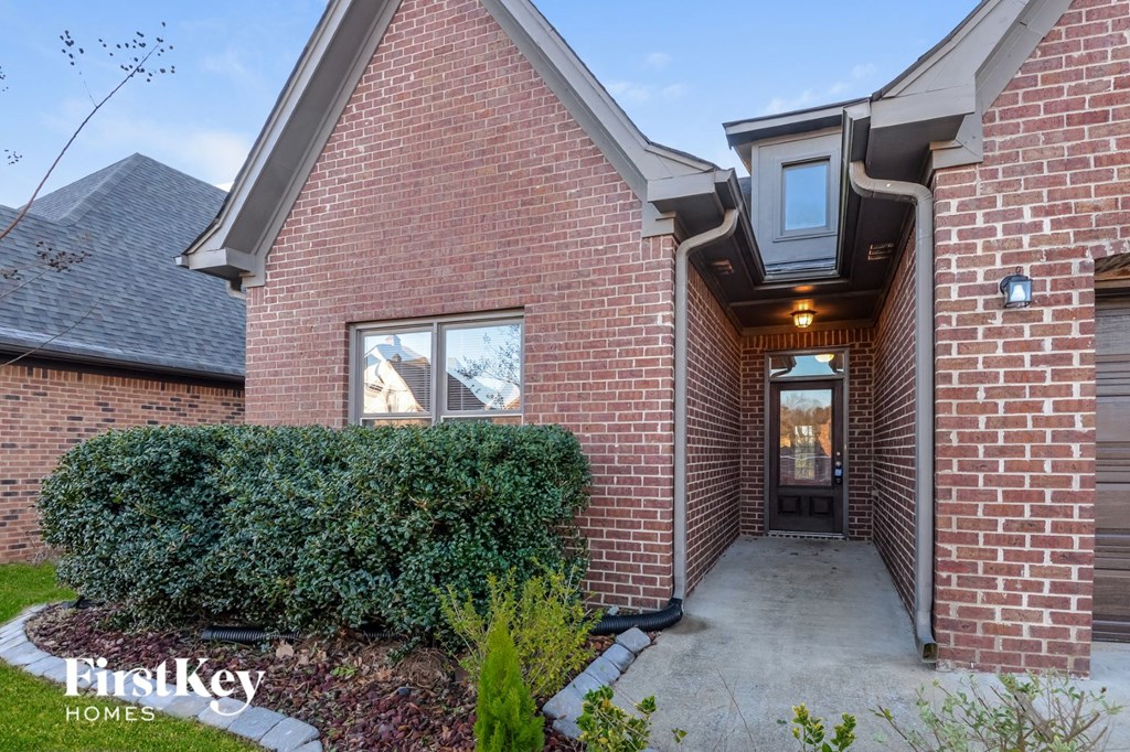 a side view of a brick house with a concrete walkway