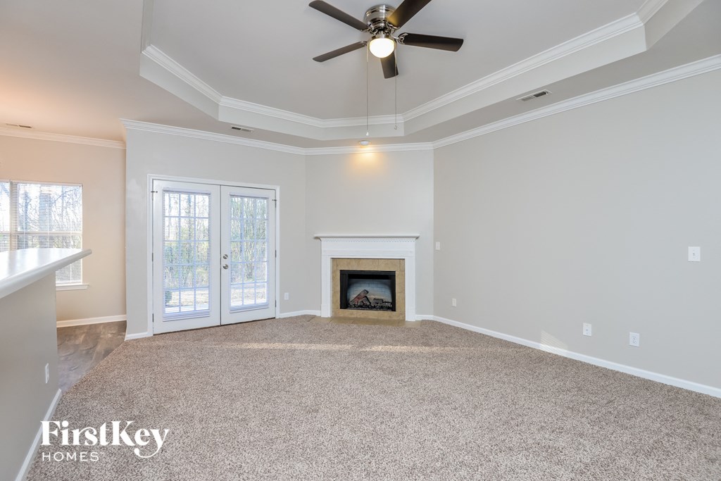 the living room with fireplace and ceiling fan