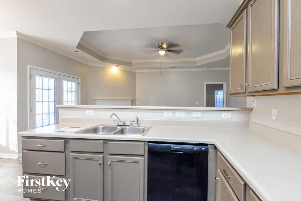 a kitchen with white counter tops and a black dishwasher