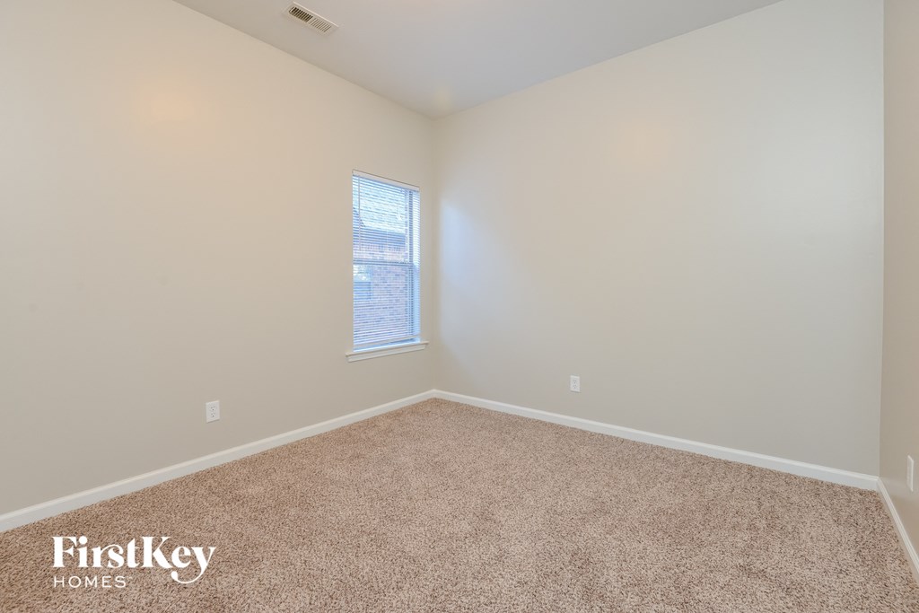 an empty room with carpet and a window