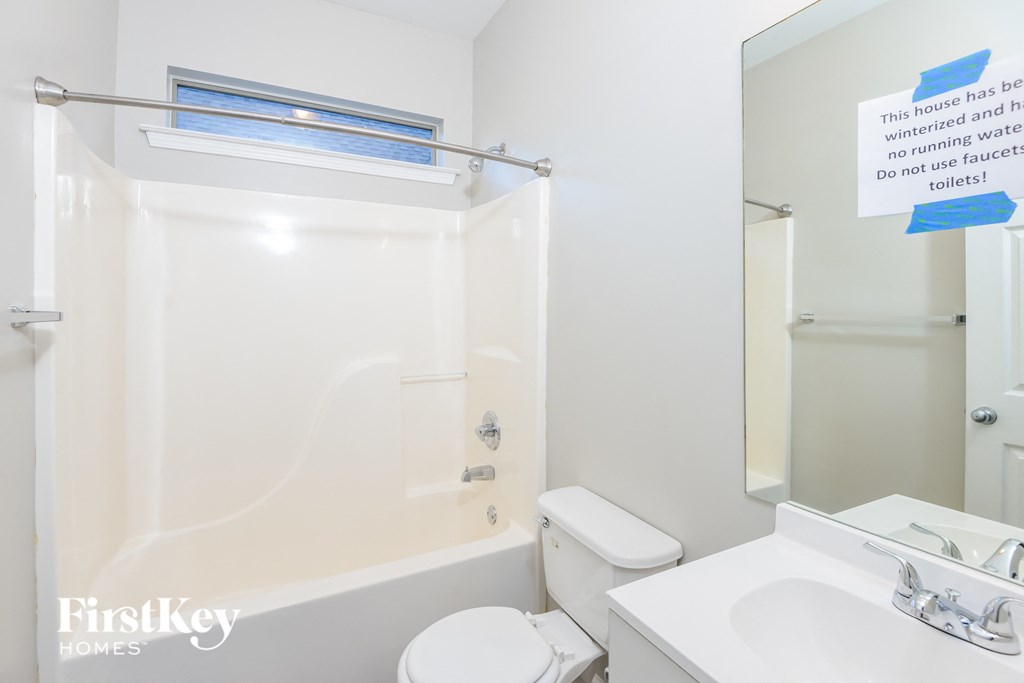 a white bathroom with a tub and a toilet and a sink