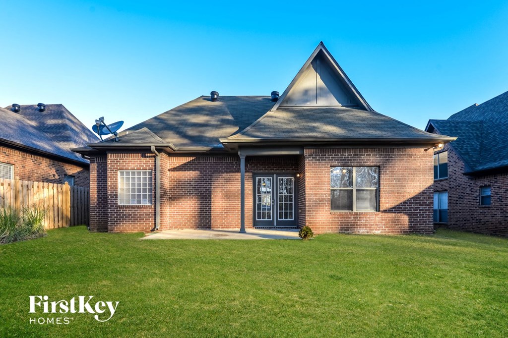 a brick house with a lawn and a fence