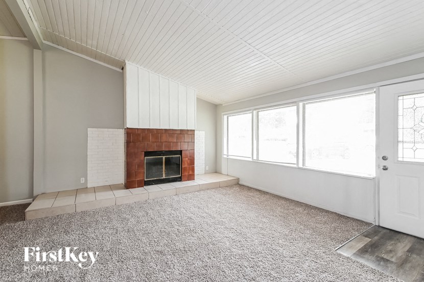 a large living room with a fireplace and a carpet