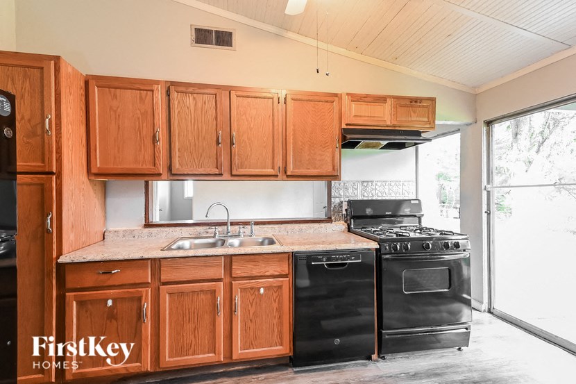 a kitchen with black appliances and wooden cabinets