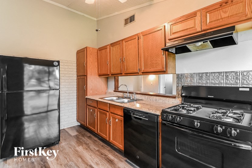 a kitchen with black appliances and wooden cabinets