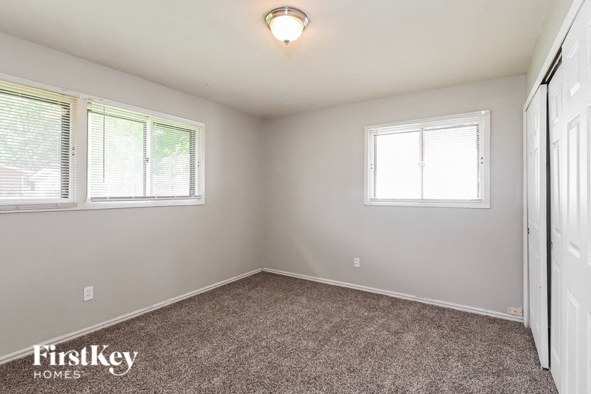 a bedroom with a carpeted floor and two windows
