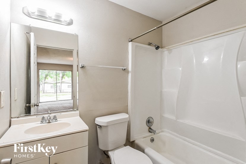 a white bathroom with a white toilet and a sink