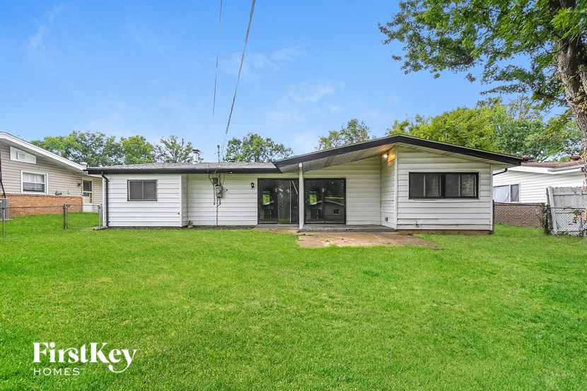 a white house with a grassy yard and a garage