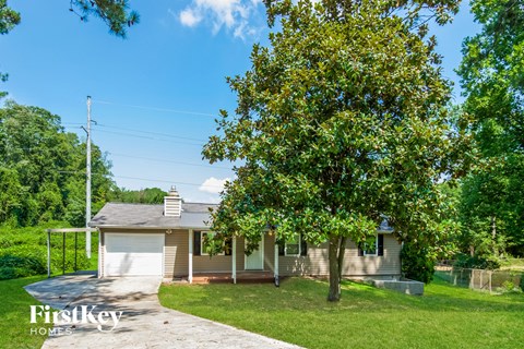 a small white house with a tree in front of it