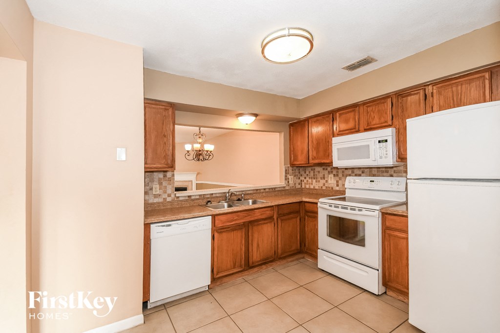 a kitchen with white appliances and wooden cabinets