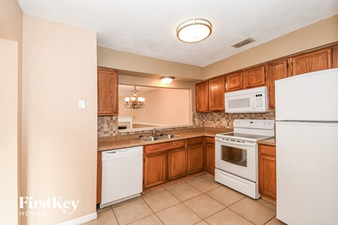 a kitchen with white appliances and wooden cabinets