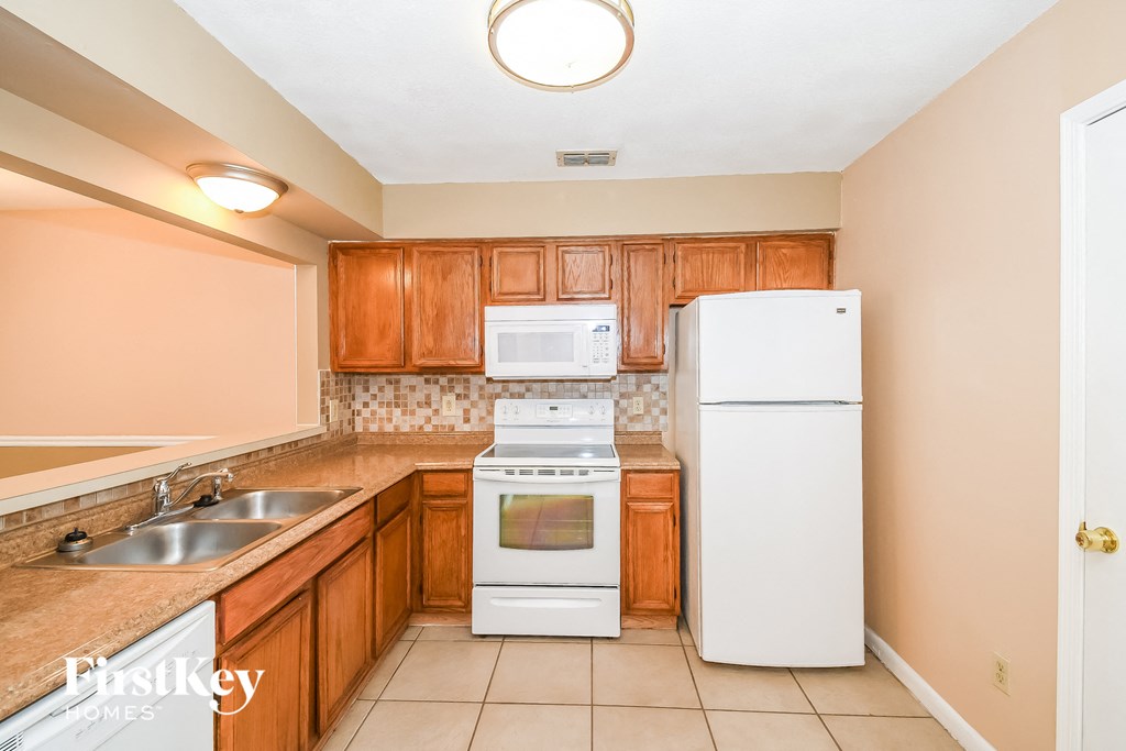 a kitchen with white appliances and wooden cabinets