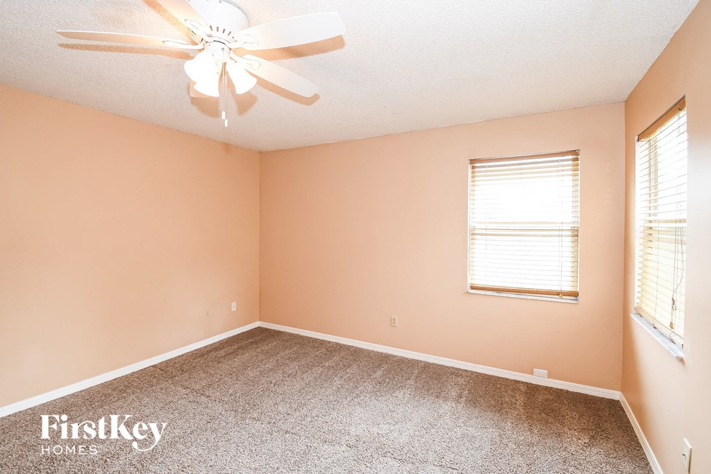 a bedroom with carpet and a ceiling fan