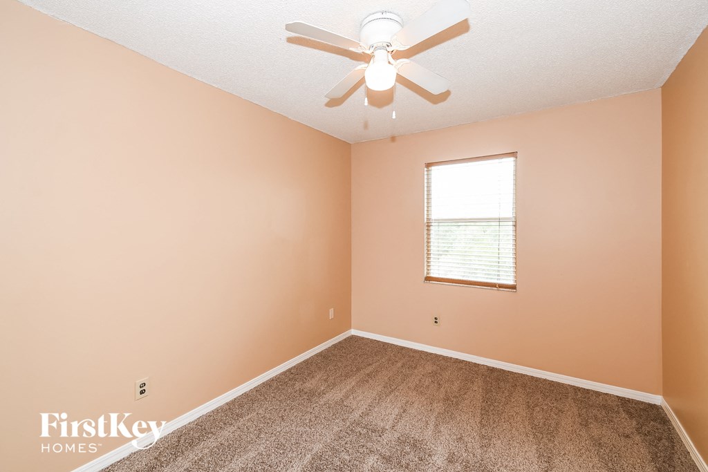 a bedroom with carpet and a ceiling fan