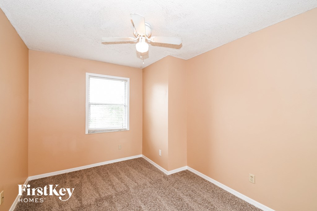 a bedroom with carpet and a ceiling fan