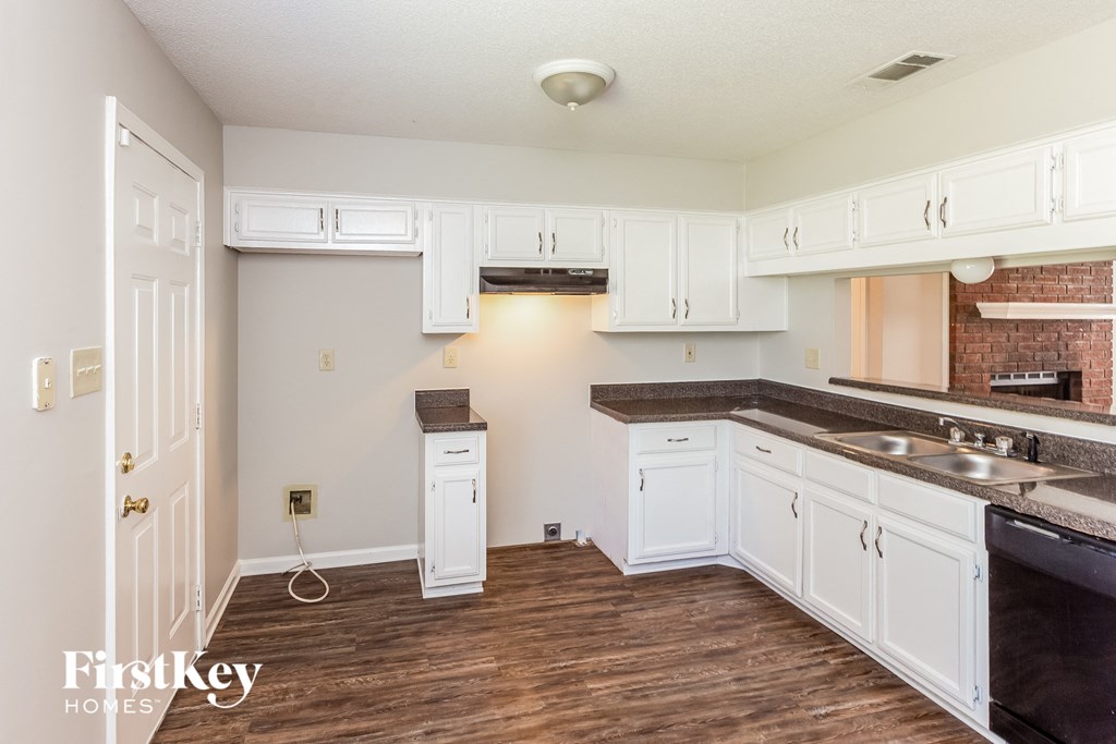 a kitchen with white cabinets and a counter top and a sink