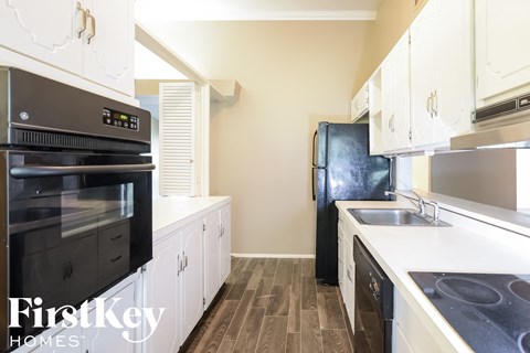 A kitchen with a black fridge and a black oven.