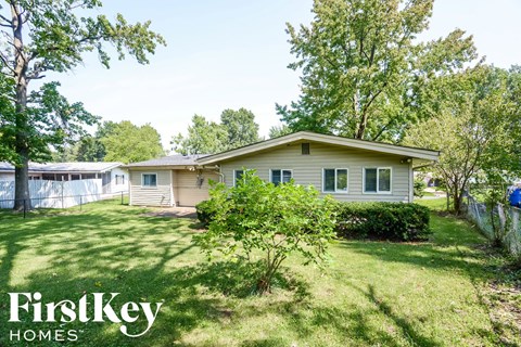 A house with a lawn and trees in the background is for sale through FirstKey Homes.