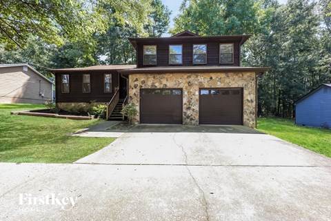 a brick house with two garage doors and a driveway