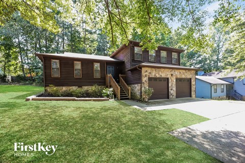 a brown house with a lawn and a garage
