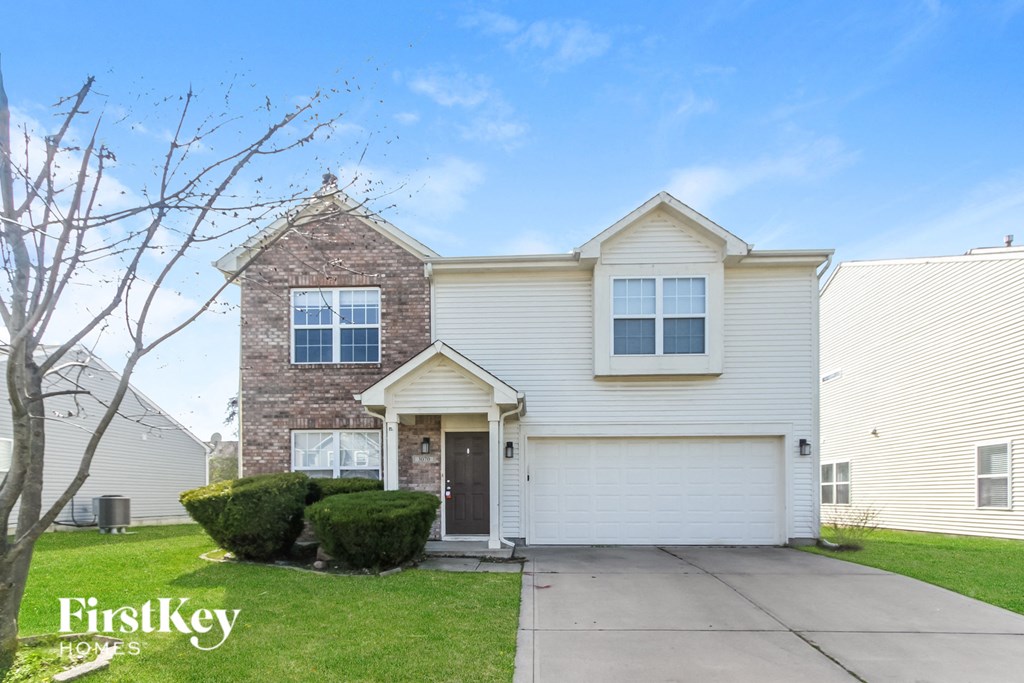 A house with a garage and a driveway is for sale.