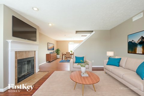 A living room with a fireplace and a painting on the wall.