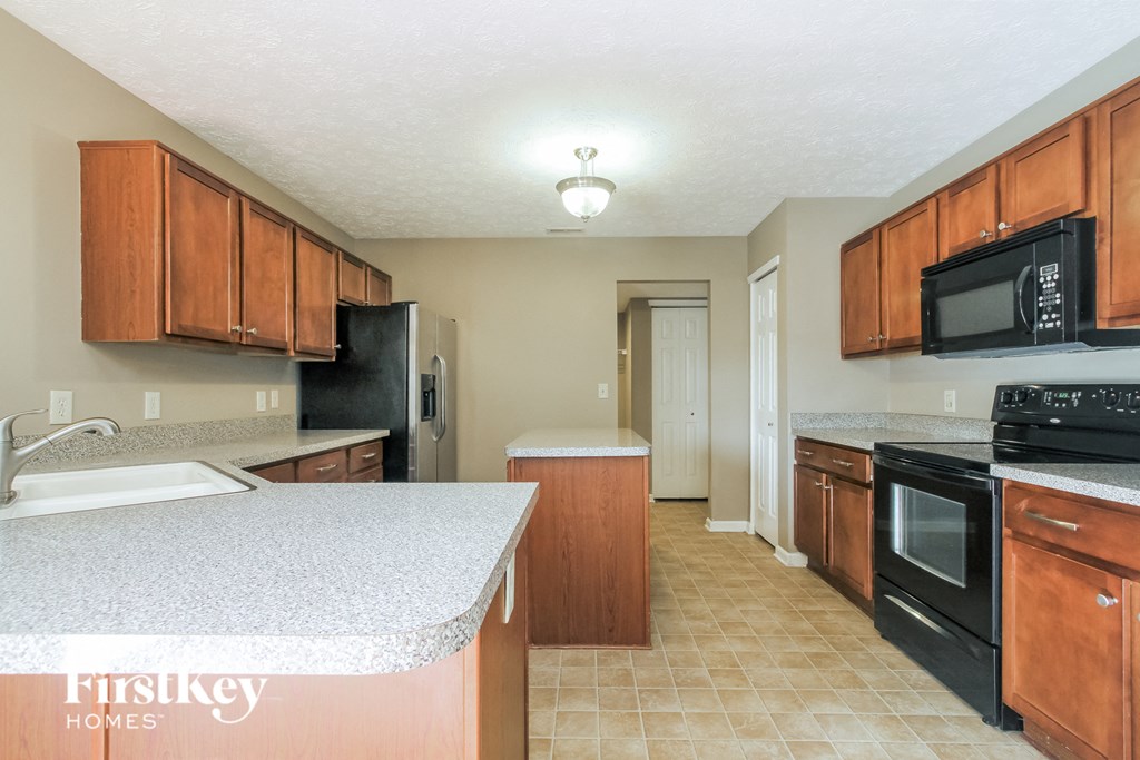 A kitchen with wooden cabinets and black appliances.
