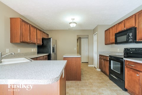 A kitchen with wooden cabinets and black appliances.