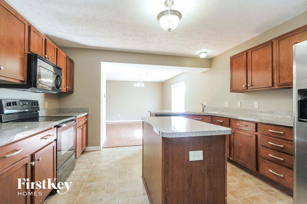 A kitchen with wooden cabinets and a stainless steel refrigerator.