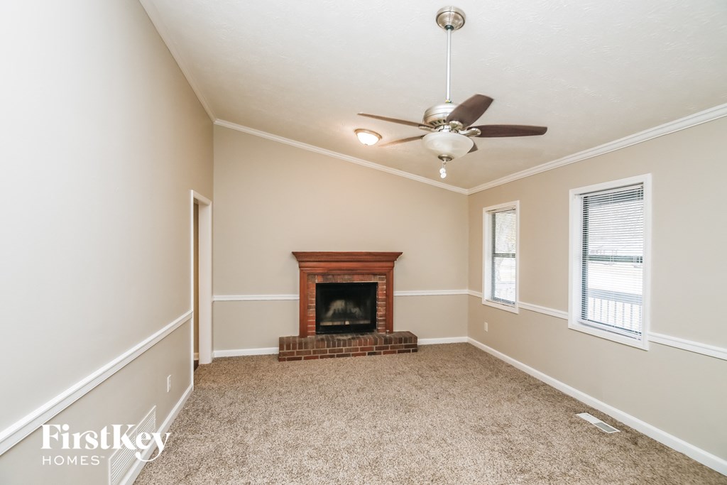 A room with a fireplace and a ceiling fan.